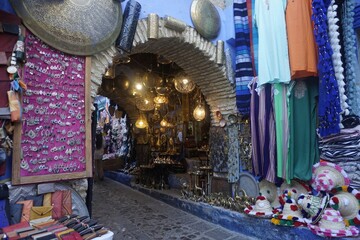 Chefchaouen, Vibrant Moroccan souk showcasing colorful textiles, lanterns, handcrafted items, and traditional decor, creating a lively and cultural shopping scene.
