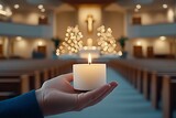  Una pequeña vela en la palma de una mano, con un altar decorado con árboles de Navidad al fondo.
