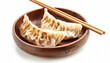 © Людмила Мазур - Bowl of dumplings with chopsticks on top. The chopsticks are wooden and are placed on top of the dumplings. The bowl is round and made of wood