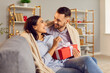 © Studio Romantic - Young affectionate couple in love, pair wrapped with warm blanket enjoy happy romantic holiday, gift present box giving, feeling close, Saint Valentine's Day celebration at home, festive studio
