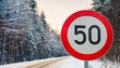 © hardvicore - Round traffic sign 50 km/h maximum, speed limit for speeding vehicles. Winter snowy background.