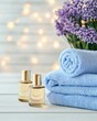 © Natalia - Luxurious spa arrangement featuring golden oils, soft blue towels, and calming purple decor on a light wooden surface for relaxation