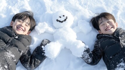 Two young boys lying in the snow with their arms around a snowman. the snowman is made of white snow and has a smiley face drawn on it.