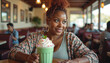 © Bolbot Visuals - Plus-sized woman holding a cup of ice cream. She has a big smile on her face. African American, casually dressed, sitting at a diner table.