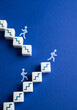 © Andrii Yalanskyi - People climb the stairs, some fall out of carelessness. The concept of moving to new levels and the risk of experiencing failures.