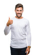 © Krakenimages.com - Young handsome man over isolated background doing happy thumbs up gesture with hand. Approving expression looking at the camera with showing success.