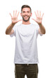 © Krakenimages.com - Young handsome man over isolated background showing and pointing up with fingers number ten while smiling confident and happy.