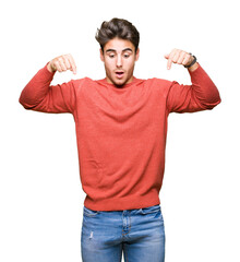 young handsome man over isolated background pointing down with fingers showing advertisement, surpri