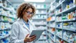 © Nelson - Pharmacist using digital tablet in pharmacy store with shelves full of medicine packages