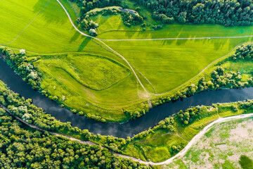 high altitude view of green landscape with river and agricultural fields