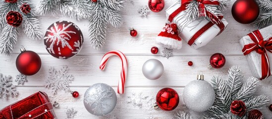 Aufkleber - Red and silver Christmas decorations on white wooden table with fir branches candy cane and gift boxes overhead view festive arrangement