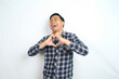 © M Alfan Setyawan - joyful asian man show heart shape with hand wearing plaid shirt isolated on white