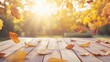 © Cyber Shutter - Autumn scene featuring vibrant dry leaves scattered on a rustic wooden table illuminated by warm sunlight in a serene outdoor setting