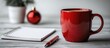 © DigitalDruid - Christmas planning scene with a red mug pen and blank notepad on a wooden table with holiday decorations in the background.