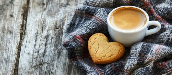 Canvas Print - Heart-shaped cookie next to a cup of coffee on a rustic wooden table with a plaid cloth and ample copy space for text integration