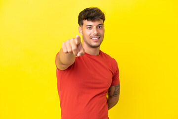 Sticker - Young caucasian handsome man isolated on yellow background pointing front with happy expression