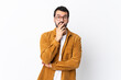 © luismolinero - Caucasian handsome man with beard wearing a corduroy jacket over isolated white background surprised and shocked while looking right