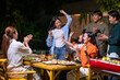 © Wasana - A group of people are gathered around a table with food and drinks