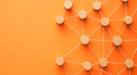 Representing a network of dots with interconnected wooden dots on an orange background. Connection and networking concept. Teamwork and collaboration concept in employment.
