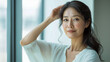© smth.design - Asian Mature Female Smiling by Window in Soft Light