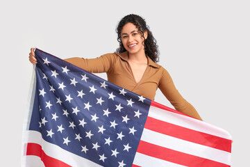 Wall Mural - Beautiful young happy African-American woman with USA flag on white background