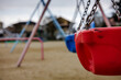© Thomas G Weber - Close-up horizontal view of an infant swing in a typical, Japanese inner city neighborhood playground. The bokeh backdrop features neighborhood homes.