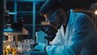 © Galib - A scientist in a lab coat and safety glasses examines a sample under a microscope.