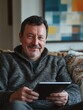 © Elena - Relaxed Man Enjoying Digital Entertainment on Tablet