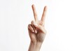 © Oleh - Female hand gesturing peace or victory sign with two fingers raised up on an isolated white background, representing concepts of counting, agreement, or non-verbal communication