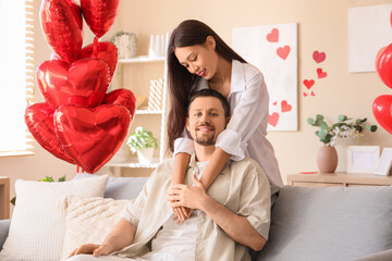 Canvas Print - Young Asian woman hugging her husband at home on Valentine's Day