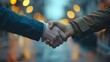 © NDmCX-Nic - Two hands shake in a blurred urban setting, symbolizing agreement, partnership, and connection amidst soft evening lights.