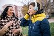 © Mediteraneo - A young boy walking down a city street alongside his mother, both dressed in warm winter clothing