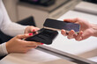 © Svitlana - Female receptionist suggesting pos terminal to client who paying contactless