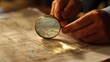 © Kitta Studio - Close-Up of Hands Using a Magnifying Glass to Examine Detailed Blueprints on a Wooden Surface in a Well-Lit Workspace, Highlighting Precision and Focus