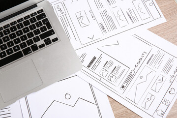 Wall Mural - developing ui design. sketches of website wireframes and laptop on wooden table, top view