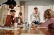 © Zamrznuti tonovi - Diverse team collaborating on project, manager leading brainstorming session in modern office