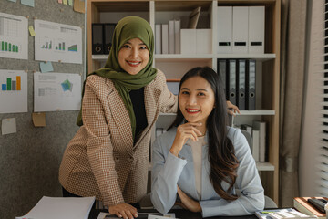 Wall Mural - A very talented Muslim businesswoman wears the hijab to show her faith. A company with many businesspeople and employees of different faiths and religions work together peacefully.