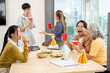 © Kittipong - Smiling, cheerful diverse Asian employees enjoy drinks and conversations while celebrating their successful project at an office party. team building, celebration, office party, teamwork