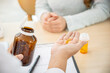 © Kittipong - A close-up of a doctor explaining the instructions for the medication to a patient during the visit in an examination room. health care concept