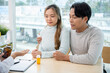 © Kittipong - A professional senior Asian female doctor in a uniform having a consultation with a young married couple in the examination room. doctor visit, health care, medical