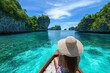 © grey - A female traveller on a boat enjoy the beautiful scenery at an ocean with crystal clear water surrounded by islands
