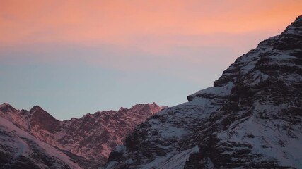 Wall Mural - Orange clouds above the snowy Himalayan mountain peak during sunset in the winter season at Sissu village in Lahaul valley, Himachal Pradesh, India. Scenic view of Himalayas in winter season.