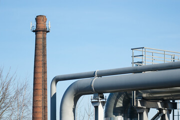 pipeline and brick chimney against blue sky