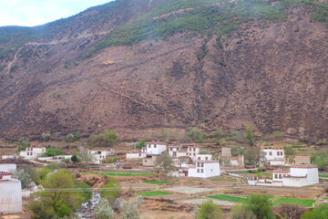 Wall Mural - Views of Tibetan houses, green field and mountains along the road from Shangri La to Yading, Sichuan 