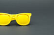 © ibragimova - A pair of sunglasses with yellow lenses. Black and yellow glasses on a black background. Yellow glasses black background fashion bright. Black and yellow glasses with a black background lifestyle in.