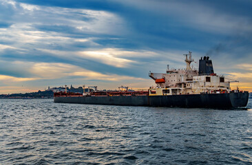 A large tanker ship sails along the Bosphorus against the background of Istanbul, Turkey, a view from a pleasure boat