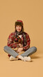 © master1305 - Smiling young man in hat and checkered jacket sitting with happy pet, Pug dog in knitted hat, with tongue sticking out, against studio background. Concept of animal, winter season, friendship, fashion
