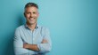 © Настя Шевчук - Happy mature man in his forties wearing casual shirt standing isolated on blue background. Smiling middle aged professional businessman looking at camera with arms crossed, portrait.