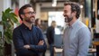 © addymawy - Two Smiling Men Converse in an Office Setting
