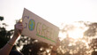 © ChayTee - Go green people young woman hand raised showing save the earth planet world care banner poster sign in city nature tree sun light sunset. Plastic free issues Protect future asian hope net zero waste